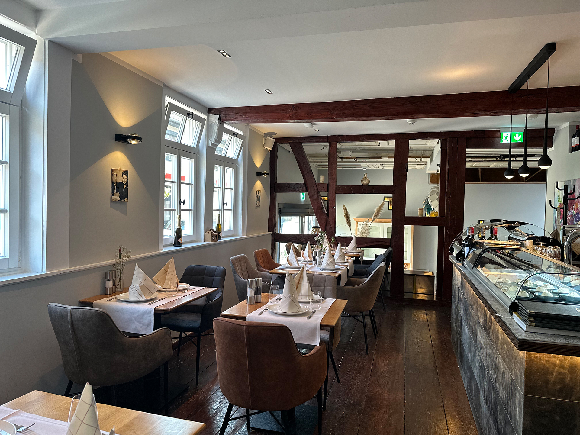 Sie sehen den Gastraum des "L'Arte della Pasta". Es ist in einem schönen Altbau mit freiliegenden Holzelementen.